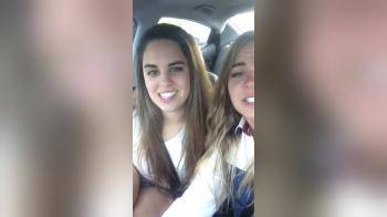 video of two girls singing in the car and kissing