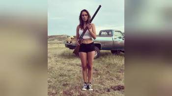 video of Brunette with hard nipples plays with a rifle