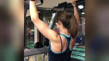 video of fit girl in the gym doing pull ups