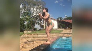 video of Dancing brunette near the pool shaking her ass