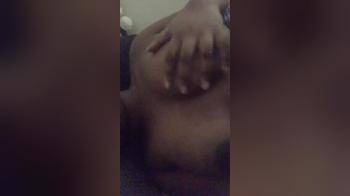 video of Black girl lying down playing with her boob