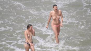 video of 3 topless girls coming out of the sea