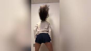video of Cute college girl against the wall strip dances