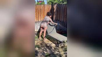 video of tattoed girl with big tits playing with water in the garden