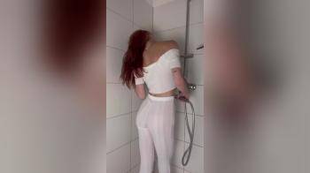 video of Girl in white clothing going to take a shower (no nudity)