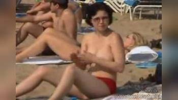 video of Rubbing lotion on big naturals at beach